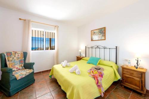 sypialnia z żółtym łóżkiem i krzesłem w obiekcie Villa Sanchez Sol by Villa Plus w mieście Torrox