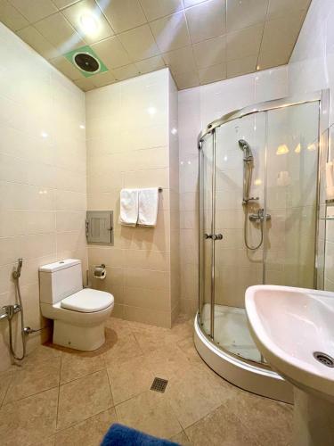 a bathroom with a shower and a toilet and a sink at Chukhur Gabala Museum Hotel in Gabala