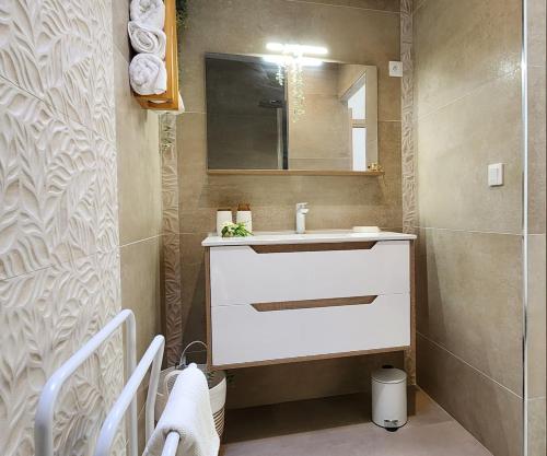 a bathroom with a white sink and a mirror at Ti Kaz Angelyn - T2 Cozy avec Spa! in Saint-André