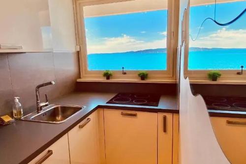 une cuisine avec un évier et une fenêtre dans l'établissement Apartment 2p with balcony facing the sea, à Saint-Raphaël