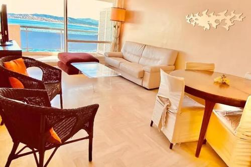 un salon avec un canapé, une table et des chaises dans l'établissement Apartment 2p with balcony facing the sea, à Saint-Raphaël