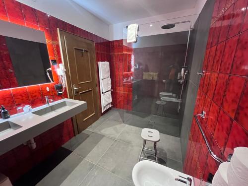 a bathroom with red tiles and a shower and a sink at Steinegger Eppan in Appiano sulla Strada del Vino
