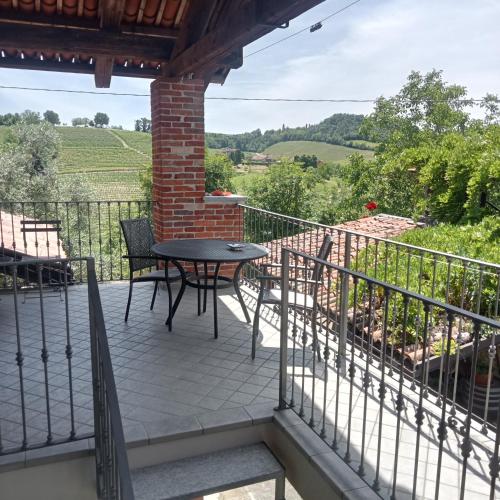 a patio with a table and chairs on a balcony at Agriturismo Bric di Gai in Monforte dʼAlba