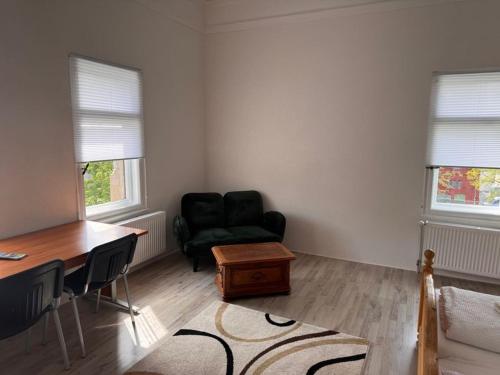 a living room with a black chair and a desk at Villa Dietel Greiz in Greiz