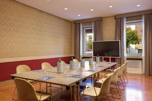 a conference room with a long table and chairs at Hotel Indigo Verona - Grand Hotel Des Arts by IHG in Verona