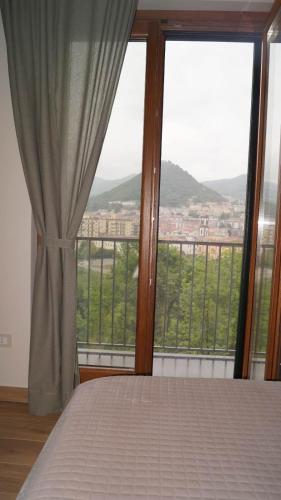 a bedroom with a bed and a large window at Terra Vitale in Cava deʼ Tirreni