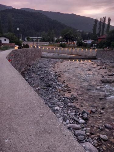 a river with rocks and lights on the side of a road at Apartment Deluxe in Peje