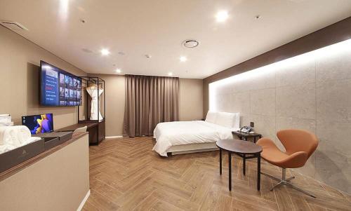 a bedroom with a bed and a table and a chair at Restia Incheon Bay Hotel in Incheon