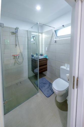 a bathroom with a glass shower and a toilet at Casa Maravilha in Caniço
