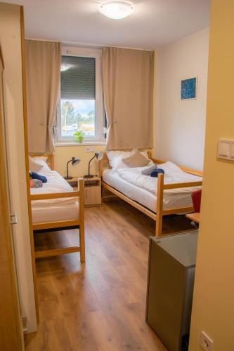 a room with two beds and a window at Aero Inn in Szeged
