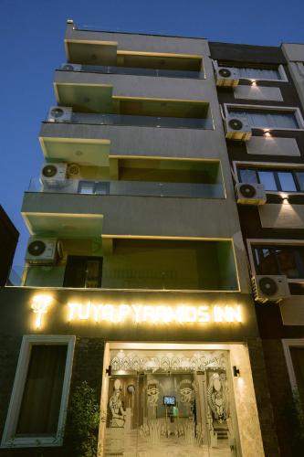 a tall building with a sign on the front of it at Tuya pyramids hotel in Cairo