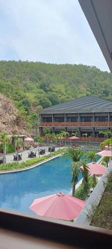 a view of a resort with a swimming pool with umbrellas at JL World Hotel Dili in Dili