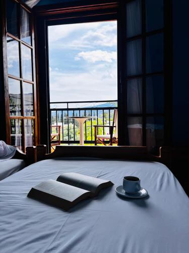 a bed with a plate and a cup and a window at Valerie's House in Poros