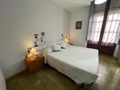 a bedroom with a bed and a nightstand with a white bedspread at Pensión Borràs in Girona