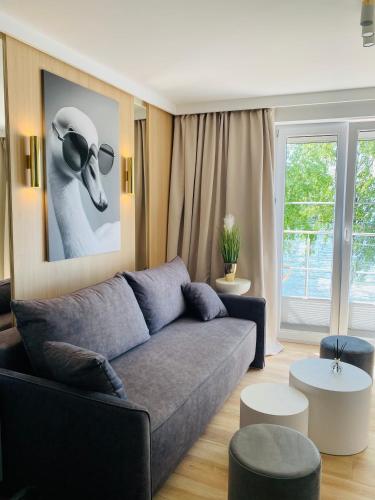 a living room with a couch and a picture of a hat at Apartament MoLoo I in Ostróda