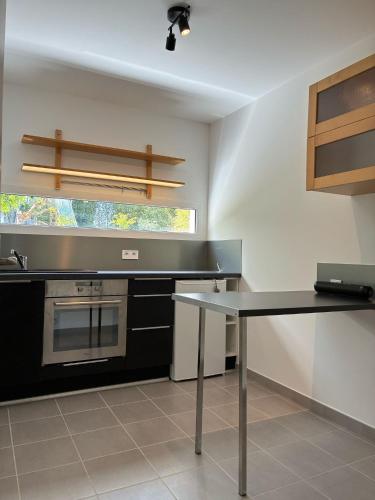 une cuisine avec une table et un comptoir dans l'établissement Appartement Rez de chaussée, au Le Verdon-sur-Mer