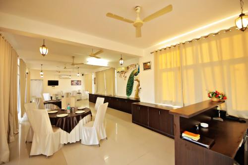 a dining room with a table and white chairs at The Park Classic Udaipur in Udaipur