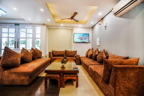 a living room with brown couches and a coffee table at HOTEL Le GRAND in Jāmb