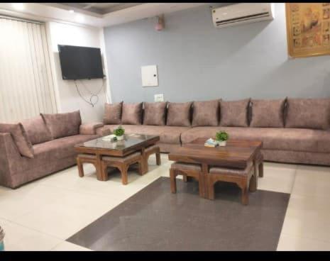a living room with a couch and two tables at HOTEL Le GRAND in Jāmb
