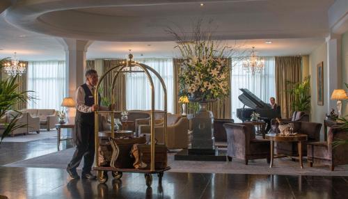 Un uomo è in piedi nella hall di un hotel di Newpark Hotel a Kilkenny