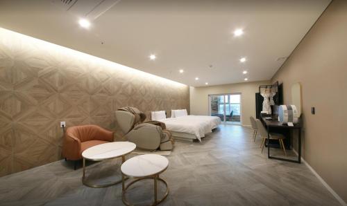a hotel room with a bed and a desk and chairs at Restia Incheon Bay Hotel in Incheon
