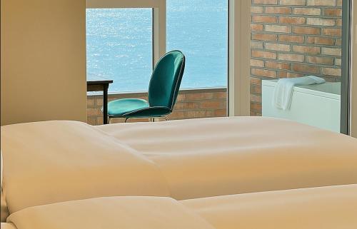 a bed and a chair in a room with a window at Restia Incheon Bay Hotel in Incheon