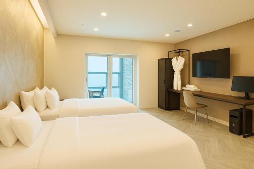 a hotel room with two beds and a television at Restia Incheon Bay Hotel in Incheon