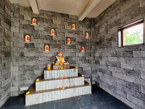 a stone wall with a staircase in a room at Pushpam Sanskruti Resort Karjat- Pure Veg in Karjat