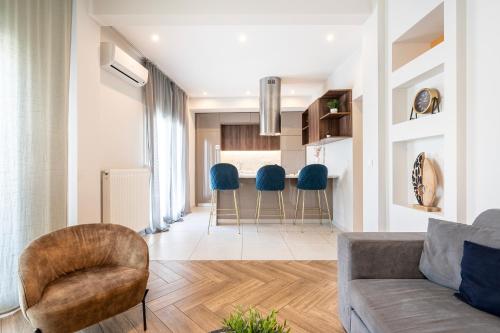 a living room with a couch and blue chairs at Houseloft Grand Vista in Thessaloniki