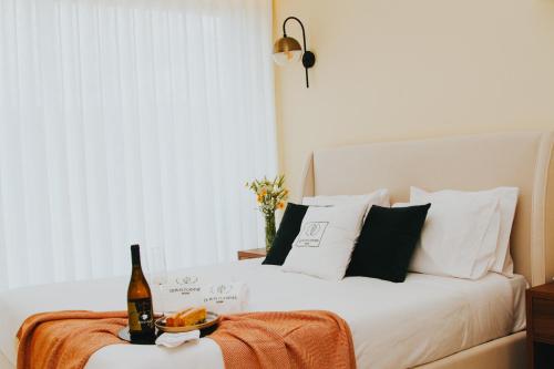 a bed with a bottle of wine and a bowl of fruit at Quinta D'Joanes Douro in Resende