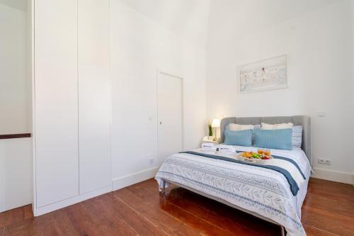 a bedroom with a bed with a bowl of fruit on it at Bright Flat in Historic Foz House by HostWise in Porto
