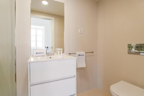 a bathroom with a white sink and a toilet at Bright Flat in Historic Foz House by HostWise in Porto