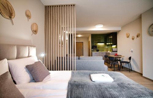 a bedroom with a white bed and a living room at Comfortable apartment, sauna Żywiec Lake in Zarzecze