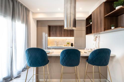 a kitchen with blue stools at a kitchen counter at Houseloft Grand Vista in Thessaloniki