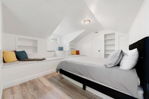 a white bedroom with a bed and a bench at Pristine 3BD, 2BA Modern Getaway with Pool in Citrus Heights