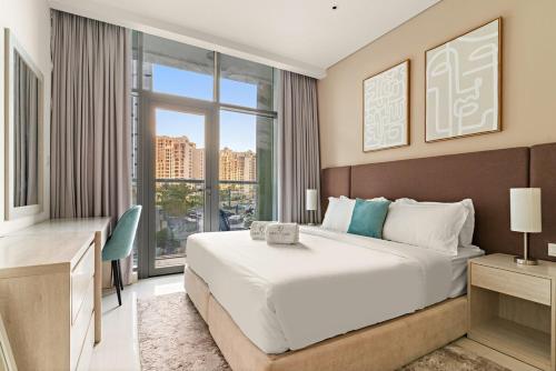 un dormitorio con una cama grande y una ventana grande en FIRST CLASS Studio Palm Paradise, en Dubái