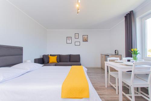 a bedroom with a bed and a table and a couch at Willa Aisza in Jastrzębia Góra