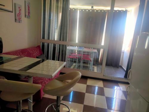 un salon avec une table et des chaises et une fenêtre dans l'établissement 6 Rue du Labech, au Cap d'Agde