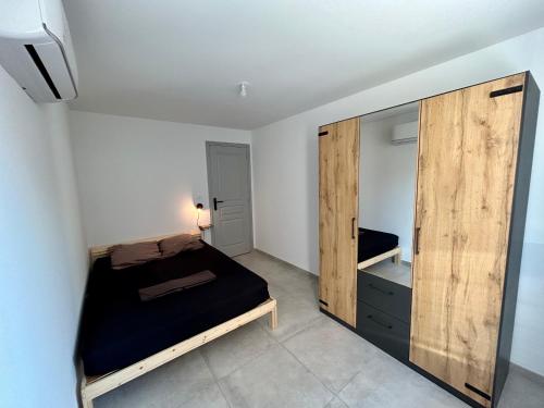 - une chambre avec un lit et une grande armoire en bois dans l'établissement 2 Minutes du Centre Historique - T3 en RDC, à Avignon