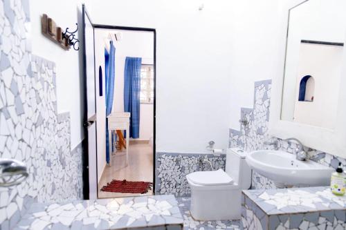 a white bathroom with a sink and a toilet at Village Susegat Beach Resort in Morjim