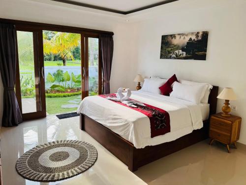 a bedroom with a large bed and a large window at Villa in Ubud