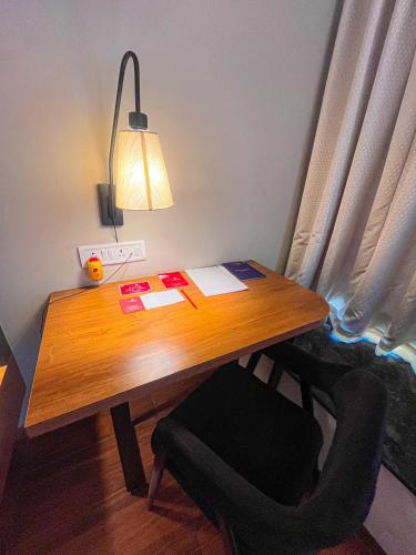 a wooden desk with a lamp and a chair at Pushpam Sanskruti Resort Karjat- Pure Veg in Karjat