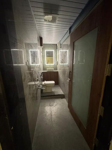 a bathroom with a toilet and a sink at Hotel Shivtara in Nānded