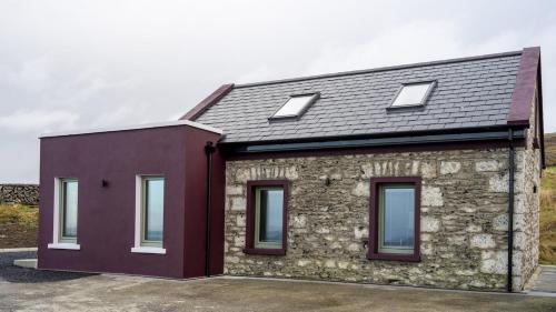 a brick and stone house with three windows at The Turning of The Tide in Fanore