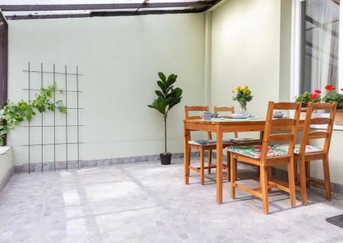 a wooden table and chairs on a patio at OHANA Apartman Emelet - Kecskemét in Kecskemét