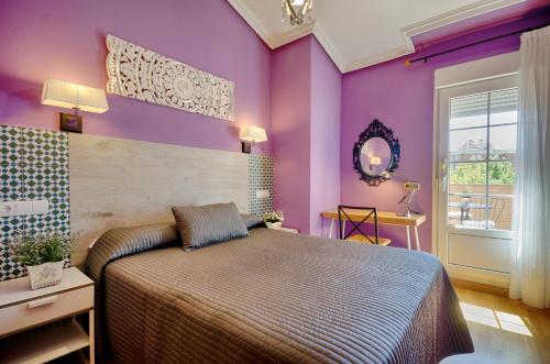 a bedroom with purple walls and a large bed at Las Abadías in Mérida