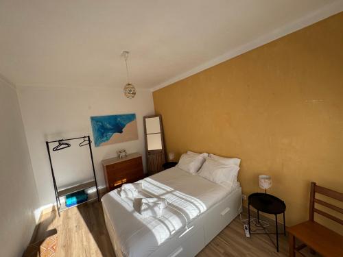 a bedroom with a white bed in a room at Foz Surfcamp in Foz do Arelho