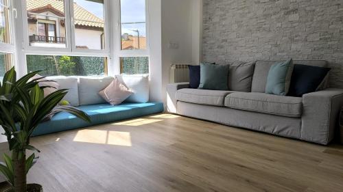 a living room with a couch and a large window at Casa Valles Verdes in Reocín