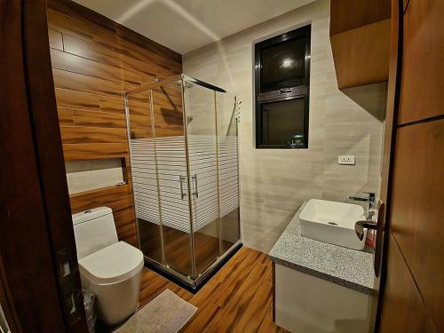 a bathroom with a shower and a toilet and a sink at Staycation At Sandari Batulao Overlooking Spot in Tagaytay