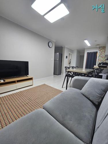 Una sala de estar con un sofá y un televisor de pantalla plana. en Nowon Station, 2 bedrooms large apartment complex, en Seúl